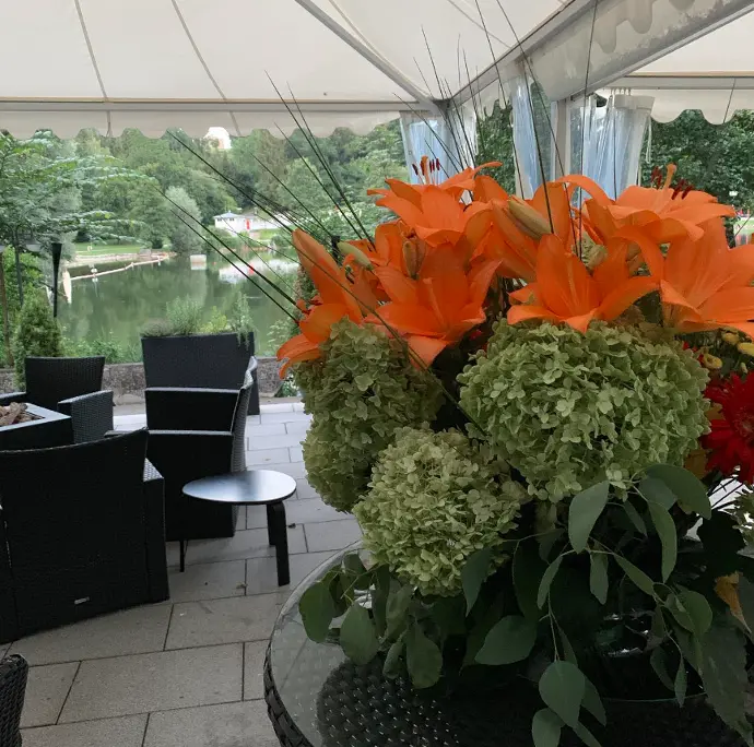 Terrasse des Haus am See mit festlich gedeckten Tischen und schönen Blumenarrangements