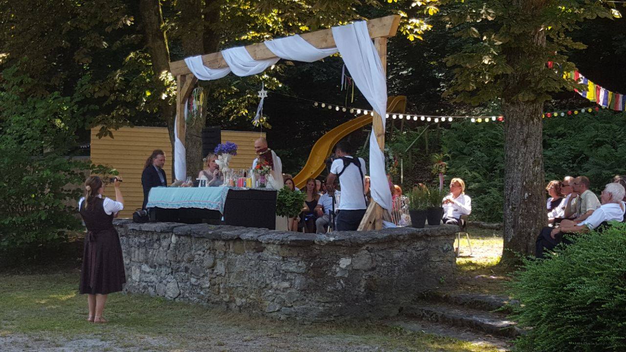 Freie Trauung am See im Garten des Haus am See unter einem Traubogen aus Holz